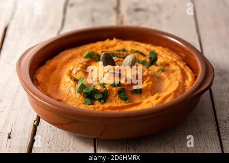 Kürbis Hummus in Schale auf Holztisch Stockfoto