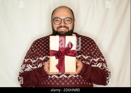 Der Mensch freut sich über ein Geschenk und hält es glücklich In der Kamera Stockfoto