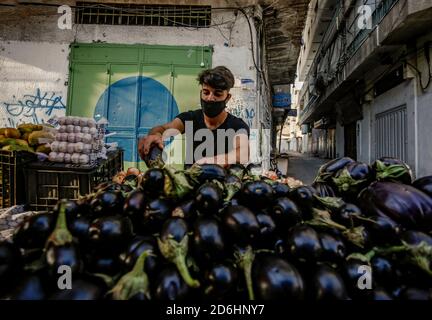 Gaza, Palästina. Oktober 2020. Ein palästinensischer Gemüseverkäufer mit Gesichtsmaske in Khan Yunis im südlichen Gaza-Streifen. Kredit: Yousef Masoud/SOPA Images/ZUMA Wire/Alamy Live Nachrichten Stockfoto