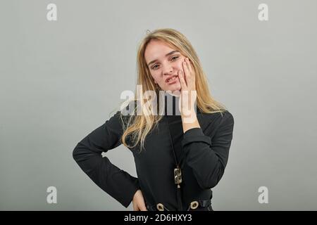 Hand auf der Wange halten, das Gesicht in den Händen ruhen, beleidigte unzufrieden Blicke mit launischen Ausdruck hält Finger Gesichtsausdruck steht verärgert. Negative Ausdrücke und Gefühle Konzept. Einzelaufnahme Stockfoto