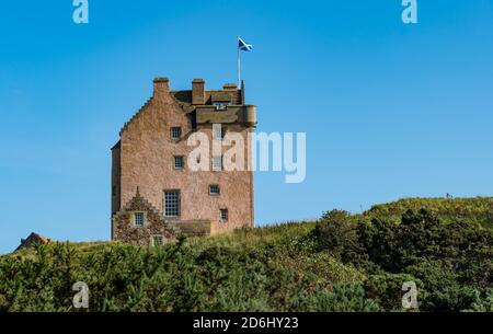 Historisches denkmalgeschütztes Gebäude, Fenton Tower, ein befestigtes schottisches Turmhaus aus dem 16. Jahrhundert mit schottischem Saltire, East Lothian, Schottland, Großbritannien Stockfoto