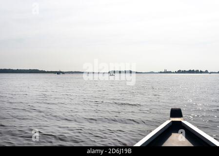 Foto aus einem Holzboot, sichtbare Menschen auf den Booten schweben, der Bug des Bootes ist verschwommen. Stockfoto