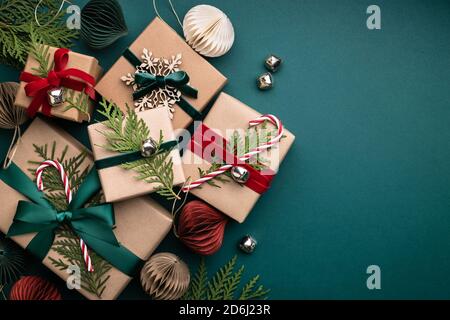 Viele Weihnachts-Geschenkboxen gebunden Samtbänder mit Papier Dekorationen auf türkisfarbenem Hintergrund. Urlaub Hintergrund in Erdfarben. Stockfoto