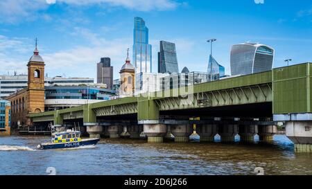 Metropolitan River Police Launch nähert sich der Cannon Street Railway Bridge, die zur Cannon Street Station London führt. Brücke eröffnet 1866, Sir John Wolfe-Barry. Stockfoto