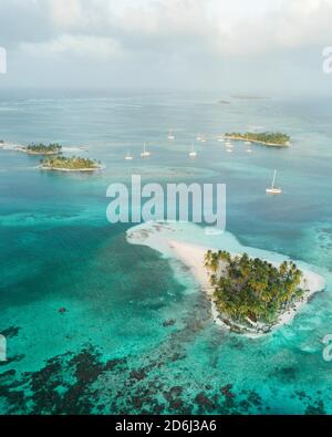 Luftaufnahme, Segelboote zwischen mehreren kleinen tropischen Palmeninseln, San Blas Inseln Stockfoto