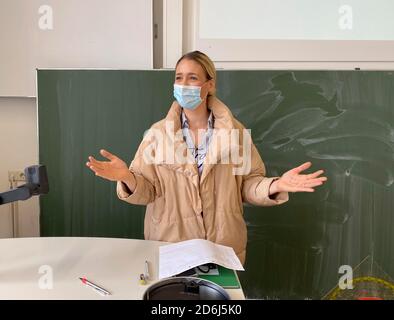 Lehrer mit dicker Winterjacke und Gesichtsmaske im Unterricht, Gesten, Corona Krise, Stuttgart, Baden-Württemberg, Deutschland Stockfoto