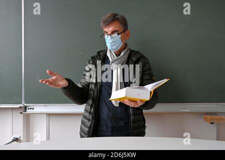 Lehrer mit dicker Winterjacke, Schal und Gesichtsmaske im Unterricht, Corona Crisis, Stuttgart, Baden-Württemberg, Deutschland Stockfoto