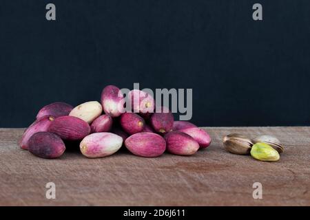 Frische Pistazien auf Holz. In Schale und geschält. Stockfoto