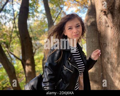 Nahaufnahme der attraktiven jungen Frau posiert in Holz. Charmante weibliche fotografiert vor der Kamera, im Wald stehend. Stockfoto