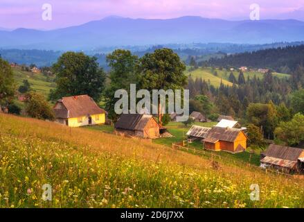 Kleine Häuser in Bergdorf bei Sonnenuntergang im Sommer in Ukraine Stockfoto