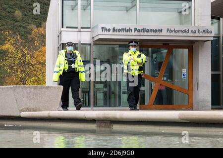Polizeibeamte mit Gesichtsmasken vor dem schottischen Parlamentsgebäude während der Coronavirus-Pandemie, Edinburgh, Schottland, Großbritannien Stockfoto