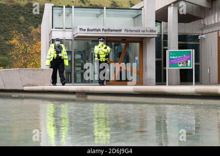 Polizeibeamte mit Gesichtsmasken vor dem schottischen Parlamentsgebäude während der Coronavirus-Pandemie, Edinburgh, Schottland, Großbritannien Stockfoto