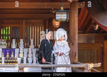 tokio, japan - oktober 10 2020: Traditionelle japanische shinto-Hochzeit eines Paares in schwarzem Haori-Kimono und weißem Shiromuku unter einer Laterne aus t Stockfoto