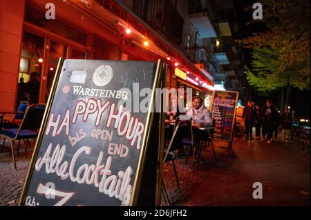 Berlin, Deutschland. Oktober 2020. Vor einer Bar in Berlin-Friedrichshain gibt es ein Schild mit der Aufschrift ''Happy Hour to open end''. Die meisten Geschäfte und alle Restaurants und Bars müssen von 23.00 bis 06.00 Uhr schließen. Quelle: Christophe Gateau/dpa/Alamy Live News Stockfoto