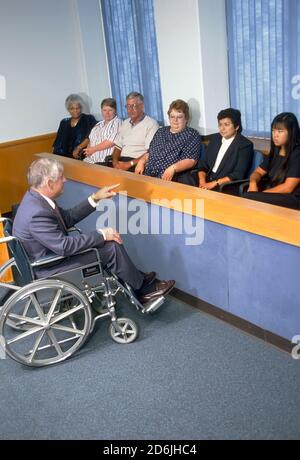 Rechtsanwalt im Rollstuhl spricht eine Gerichtskammer Jury Stockfoto