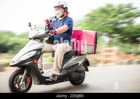 Mitarbeiter für die Lebensmittelzustellung fahren Motorräder, um Lebensmittel zu liefern Stockfoto