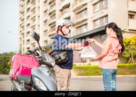 Mitarbeiter für die Lebensmittelzustellung fahren Motorräder, um Lebensmittel zu liefern Stockfoto