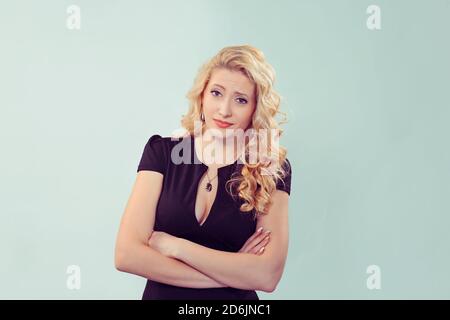 Skeptisch. Nahaufnahme lustig verwirrt zweifelhaft blond lockig Frau in schwarzem Kleid denken Planung Blick auf Sie Kamera mürrisch zweifelhaft isoliert auf Licht Stockfoto