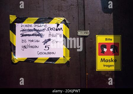 Hamburg, Deutschland. Oktober 2020. Schilder mit der Aufschrift "Liebe Gäste. Corona. Heute bis morgen um 5 Uhr geschlossen" und "Please wear a mask" hängen an der Tür eines Pubs während der Sperrstunde auf der Reeperbahn. Aufgrund der zunehmenden Zahl neuer Coronainfektionen müssen alle Hamburger Pubs erstmals um 23.00 Uhr schließen und dürfen erst um 5.00 Uhr wieder geöffnet werden. Quelle: Daniel Bockwoldt/dpa/Alamy Live News Stockfoto