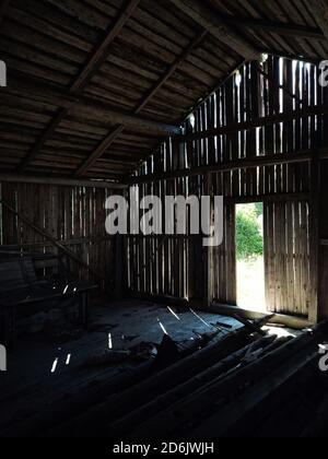 Licht, das durch Lücken in der Wand einer alten Scheune scheint. Stockfoto