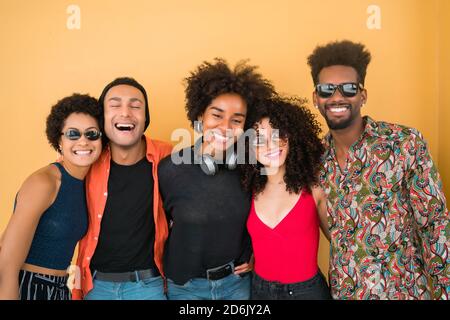 Portrait von Afro-Freunden, die zusammen Spaß haben und gute Zeit vor gelbem Hintergrund genießen. Freundschaft und Lifestyle-Konzept. Stockfoto