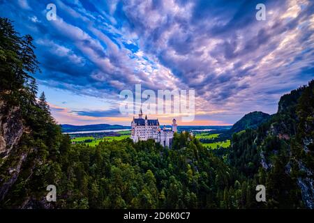 Panoramablick auf das Schloss Neuschwanstein von der Marienbrücke bei Sonnenaufgang. Stockfoto
