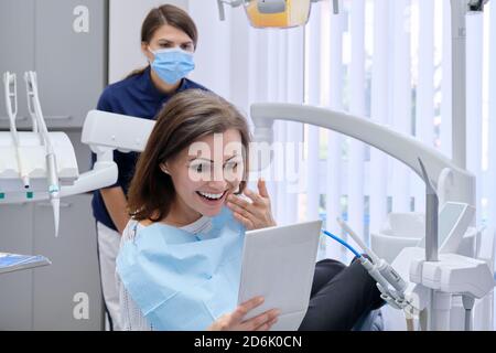 Glückliche Frau mittleren Alters mit Arzt Zahnarzt Blick in Spiegel An den Zähnen Stockfoto