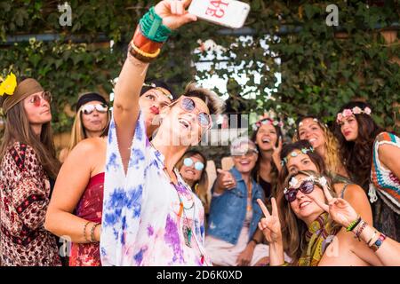 Hippy Gruppe der kaukasischen schöne Frauen auf der Suche nach einem Smartphone ein Bild oder Internet die Ergebnisse im Internet zu sehen. schöne attraktive Leute zusammen verbringen. Stockfoto