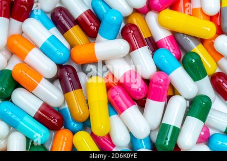 Bunte Kapsel Pillen. Pharmaindustrie. Gesundheitswesen und Medizin Hintergrund. Pharmazeutik-Konzept. Antibiotikaresistenz. Rosa, weiß. Stockfoto