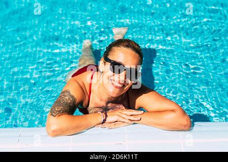 Fröhliche schöne Frau Porträt am Pool - Urlaub Sommer Urlaub im Resort für glückliche junge hübsche Leute im Bikini - gesunde Lebensweise und enjo Stockfoto