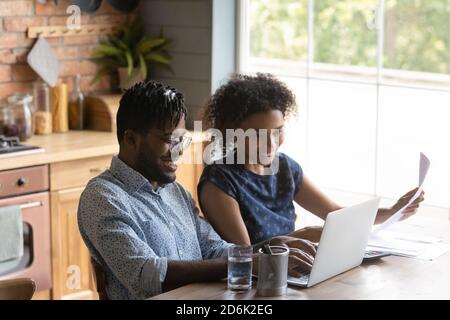 Glücklich biracial paar Rechnungen auf Laptop online bezahlen Stockfoto