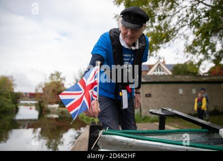 Michael Stanley, der auch als 'Major Mick', 80, bekannt ist, legt in Hunston, West Sussex, eine Unionsflagge in den Bug seines Bootes, während er sich darauf vorbereitet, mit dem selbstgemachten Ruderboot, der Tintanic, am Chichester-Kanal entlang zu rudern. Major Mick, 80, rudert in seinem selbstgemachten Ruderboot, der Tintanic, entlang des Chichester Kanals für eine 100 Meilen lange Charity Challenge, die 3 Meilen auf einmal rudert, um Geld für das St Wilfrid's Hospiz in Bosham zu sammeln. Stockfoto