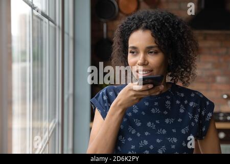 Afroamerikanische Frau aufzeichnen Sprachnachricht auf dem Smartphone Stockfoto