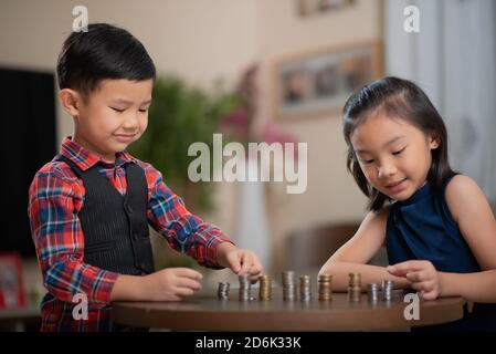 Asiatische Kinder, Finanzen verwalten, Geld zählen Stockfoto