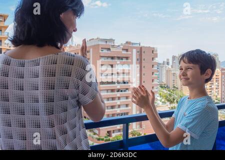 Beifall für medizinisches Personal. Familie klatscht mit den Händen, applaudiert vom Balkon, um Ärzte, Krankenschwestern, Krankenhausangestellte zu unterstützen Stockfoto