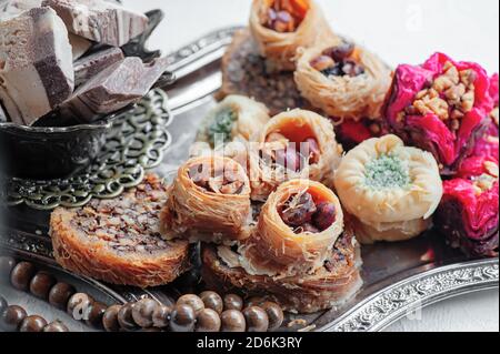 Arabische, libanesische und türkische Süßigkeiten Kataifi und Kanafeh, ein traditionelles östliches Dessert aus dünnem Teig mit Sirup, Nüssen und Samen. Nahaufnahme Stockfoto