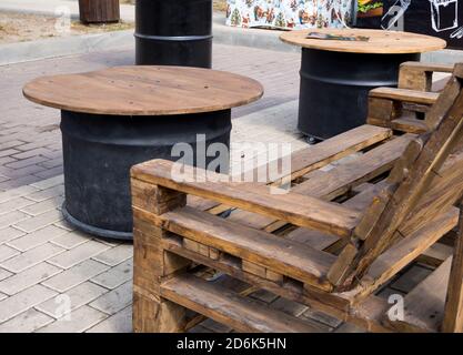 Tisch aus alten Paletten und Tische aus Metallfässern Stockfoto