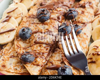 Crepes mit Schokoladennussaufstrich, Banane, Beeren Stockfoto