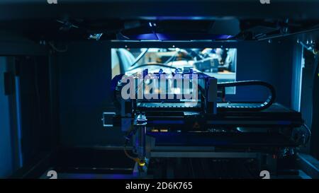 Automatisierte robotische Industrieanlagen testet elektronische Leiterplatten mit Blue Neon Light und Lasertechnologie nach der Montage. Stockfoto