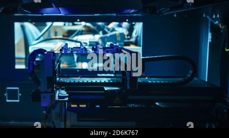 Automatisierte robotische Industrieanlagen testet elektronische Leiterplatten mit Blue Neon Light und Lasertechnologie nach der Montage. Stockfoto