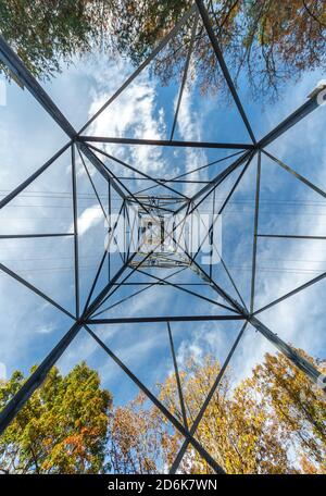 Eine abstrakte Szene geometrischer Formen, die von unten auf einen elektrischen Turm geschaut wird. Stockfoto