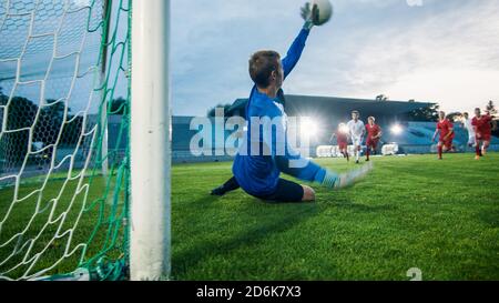 Auf Stadion Angreifer Kicks the Ball und Tore, Fußball Torwart versucht, Tore springt und fangen den Ball zu verteidigen. Stockfoto