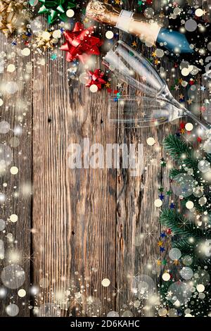 Weihnachten Holzhintergrund mit fallendem Schnee, Champagner, Gläser, flauschige Tannenzweige und festliche Einrichtung, Kopieplatz für Text, Draufsicht Kopieplatz Stockfoto