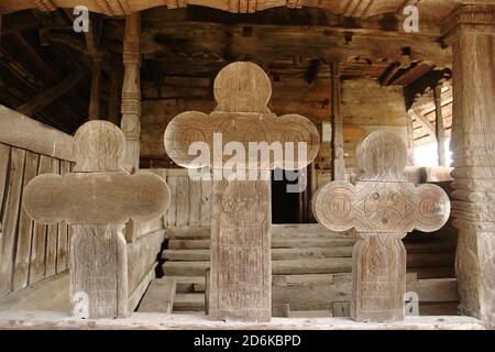 Die christlich-orthodoxe Kirche aus dem 18. Jahrhundert in Leleasca, Kreis Olt, Rumänien. Nahaufnahme der handgefertigten Holzkreuze auf der traditionellen Veranda. Stockfoto