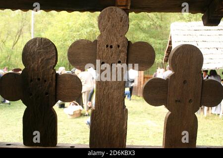 Die christlich-orthodoxe Kirche aus dem 18. Jahrhundert in Leleasca, Kreis Olt, Rumänien. Nahaufnahme der handgefertigten Holzkreuze auf der traditionellen Veranda. Stockfoto