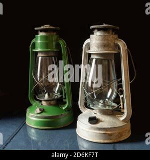Die immer alte Lampe auf dem Tisch mit Reflexion auf schwarzem Hintergrund. Laterale Nahaufnahme Stockfoto