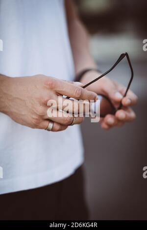 Mann hält schwarze Sonnenbrille in den Händen Stockfoto