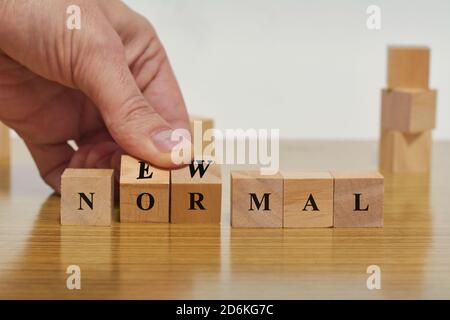 Hand Spiegeln Holzblock Würfel für neue normale Aufschrift. Anpassung an neues Leben oder Geschäft nach der Sperrung nach einer Coronavirus-Pandemie. Leben nach Pandemi Stockfoto