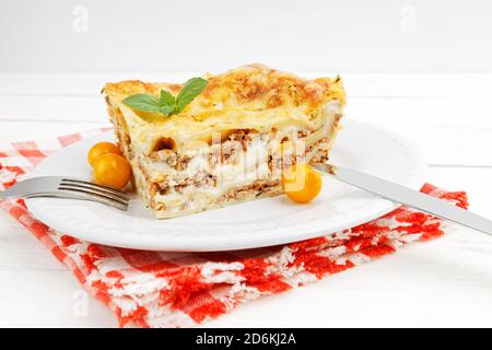 Nahaufnahme der hausgemachten Lasagne auf weißem Holztisch. Mediterrane italienische Küche. Stockfoto