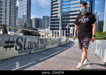 Ein Mann mit Gesichtsbemaler geht an einem '#StandWithThailand' Graffiti in Hongkong vorbei. Hongkonger Aktivisten haben ihre Solidarität mit Thailands pro-demokratischer Bewegung in den sozialen Medien mit den Hashtags '#StandWithThailand' und '#MilkTeaAlliance', einem Verweis auf eine Koalition asiatischer pro-demokratischer Aktivisten, zum Ausdruck gebracht. Stockfoto